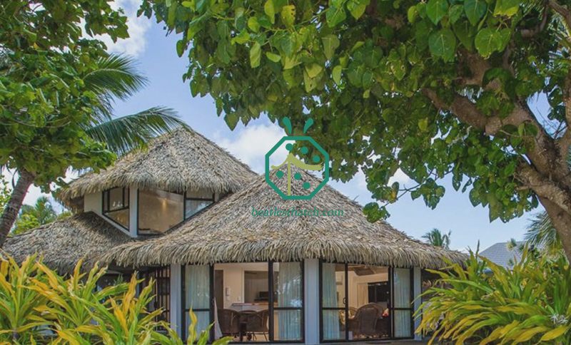 Sostituzione del tetto di paglia della camera degli ospiti di una villa sulla spiaggia di un resort rifugio con tegole in plastica di palma