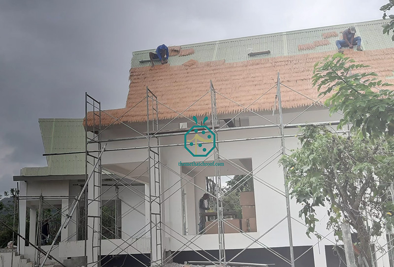 Installazione durevole del tetto di paglia da parte dei lavoratori